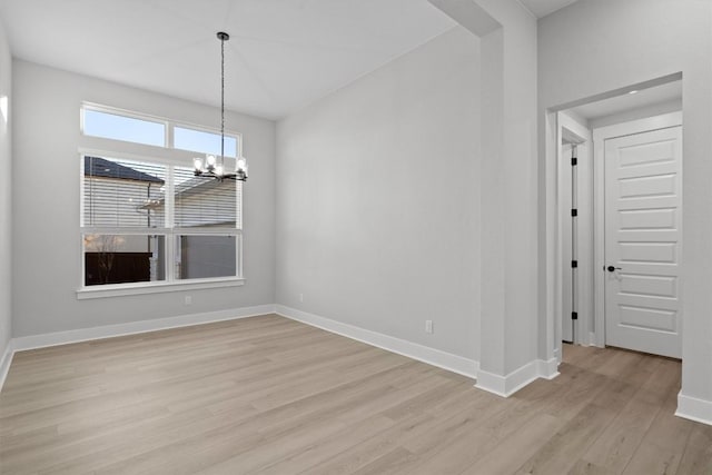 unfurnished dining area featuring light hardwood / wood-style floors and a notable chandelier