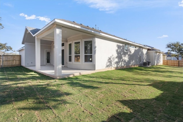 back of house featuring central air condition unit, a yard, and a patio