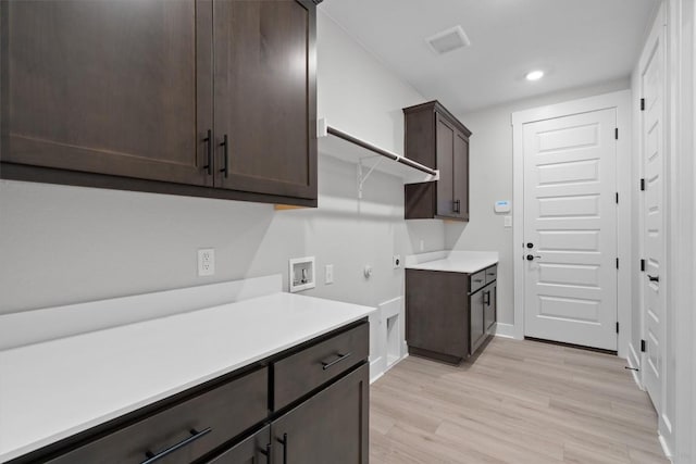 kitchen with dark brown cabinetry and light wood-type flooring