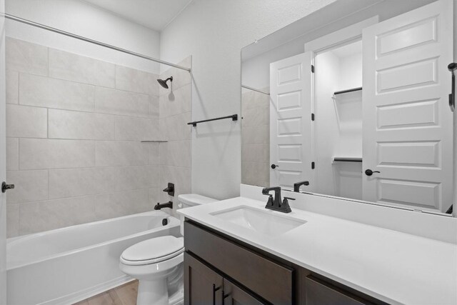 full bathroom featuring wood-type flooring, vanity, toilet, and tiled shower / bath