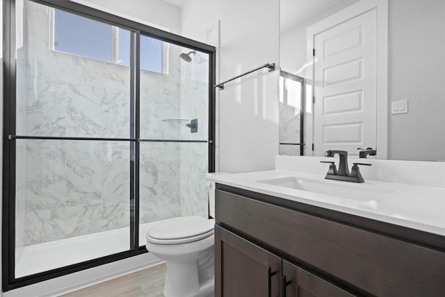 bathroom featuring vanity, toilet, and a shower with shower door