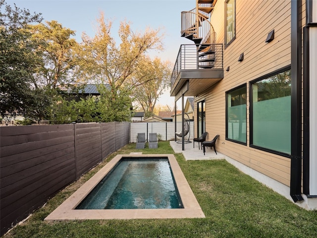 view of pool featuring a lawn and a patio