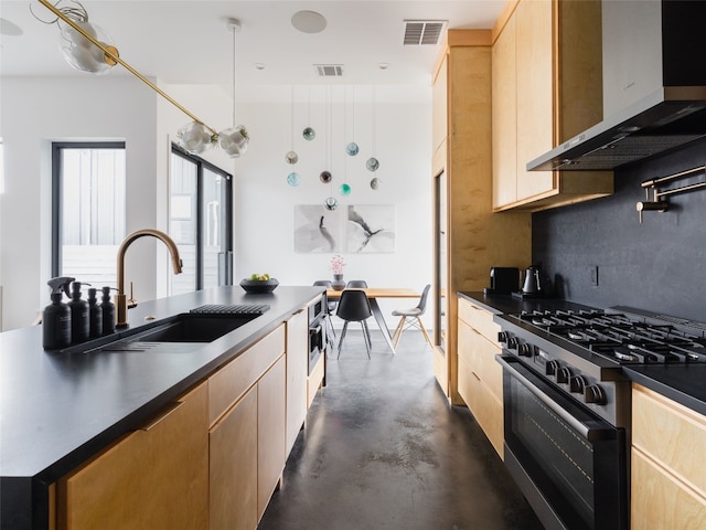 kitchen featuring high end range, decorative backsplash, wall chimney exhaust hood, sink, and light brown cabinets