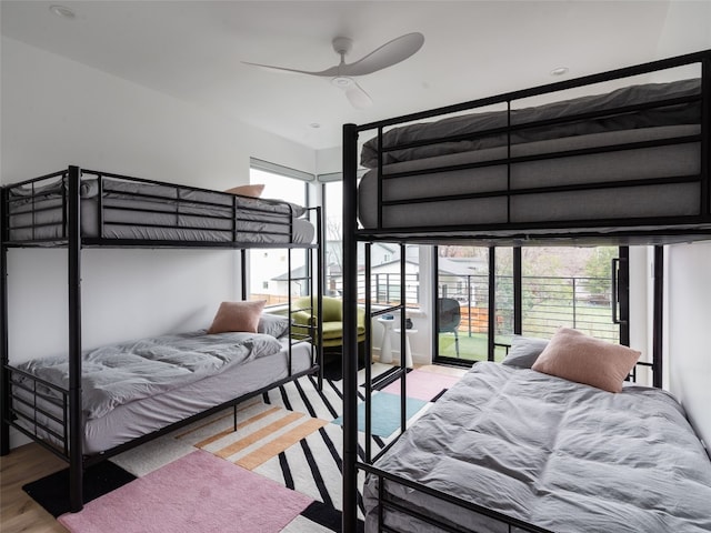 bedroom with hardwood / wood-style floors, ceiling fan, and access to outside