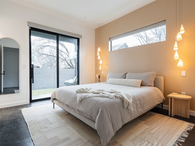 bedroom featuring access to outside and concrete floors