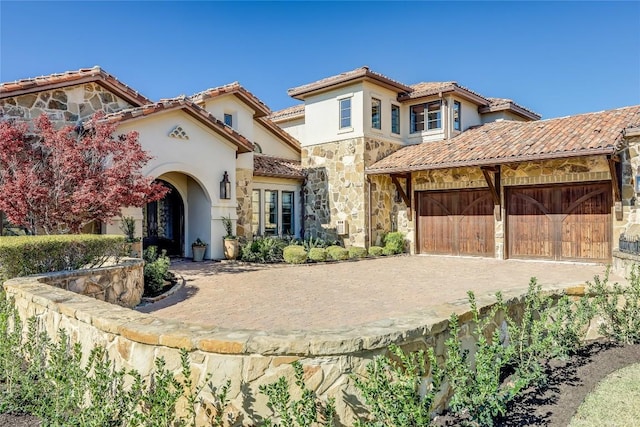 403 Rough Hollow Cv, Austin, TX 78734 - mediterranean / spanish home featuring stone siding, stucco siding, driveway, and a tile roof