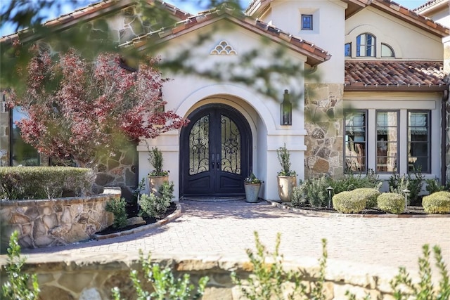 403 Rough Hollow Cv, Austin, TX 78734 - entrance to property with french doors, a tile roof, and stucco siding