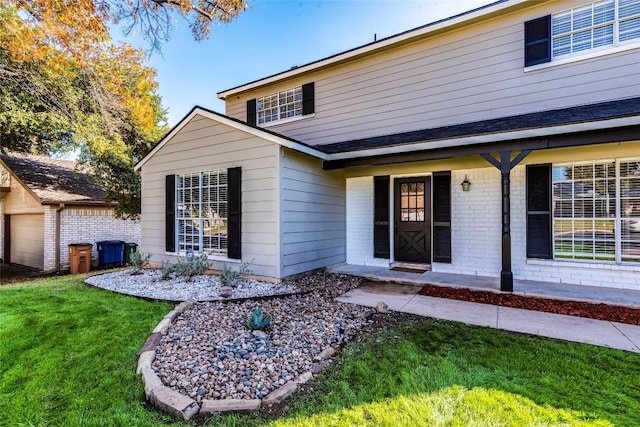 back of house featuring a garage and a lawn