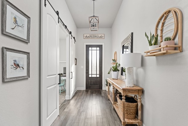 foyer with wood-type flooring and a barn door