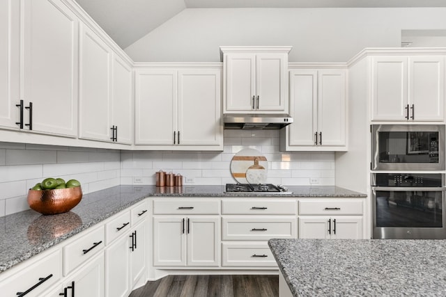 kitchen featuring white cabinetry, appliances with stainless steel finishes, vaulted ceiling, and decorative backsplash