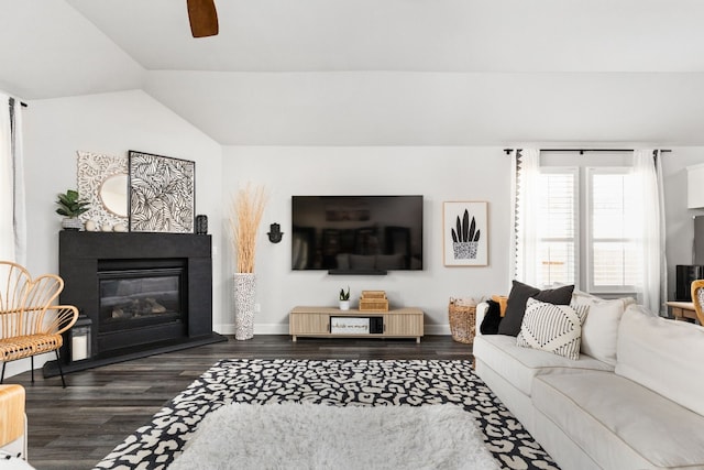 living room featuring vaulted ceiling, dark hardwood / wood-style floors, and ceiling fan