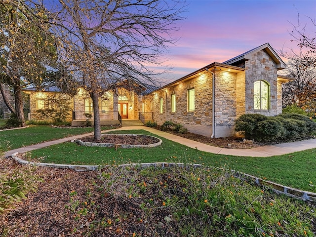 property exterior at dusk featuring a lawn