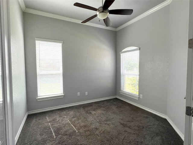 empty room featuring dark carpet, plenty of natural light, crown molding, and ceiling fan