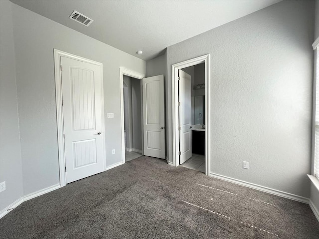 unfurnished bedroom with carpet and connected bathroom