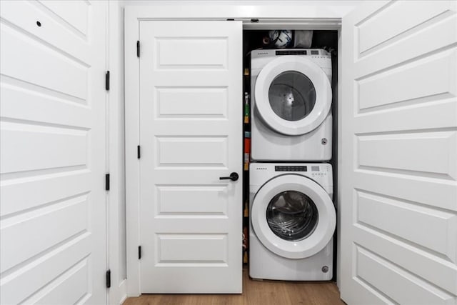 laundry area featuring light hardwood / wood-style floors and stacked washer / drying machine