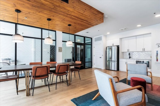 interior space featuring floor to ceiling windows, light wood-type flooring, and wooden ceiling