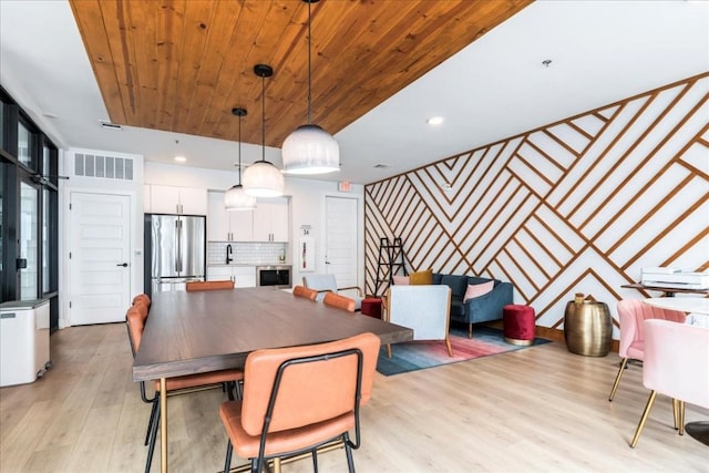 dining area with sink, beverage cooler, wood ceiling, and light hardwood / wood-style floors