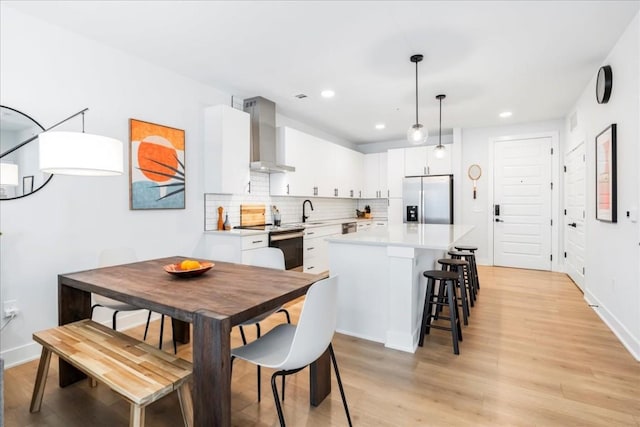 dining area featuring light wood-type flooring and sink