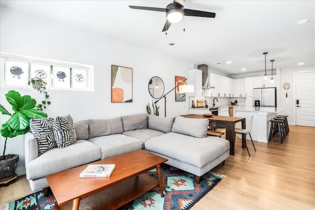 living room with light hardwood / wood-style floors and ceiling fan