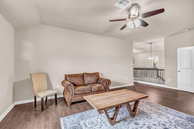 living room featuring ceiling fan with notable chandelier, dark hardwood / wood-style floors, and lofted ceiling