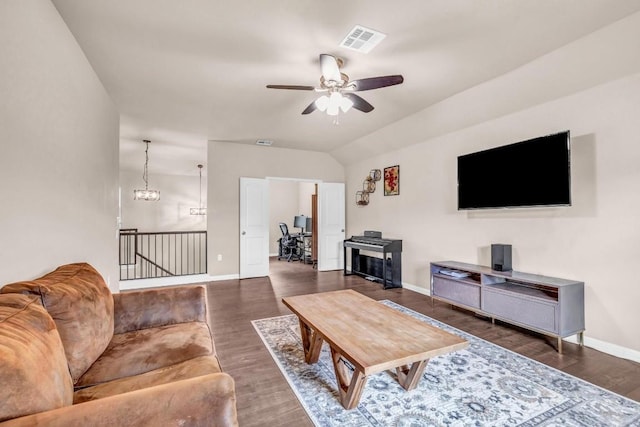 living room featuring ceiling fan with notable chandelier, dark hardwood / wood-style floors, and vaulted ceiling