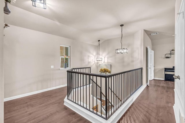 corridor featuring lofted ceiling, dark hardwood / wood-style floors, and a notable chandelier