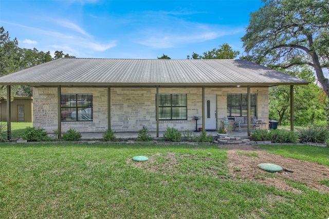 ranch-style home featuring covered porch and a front yard