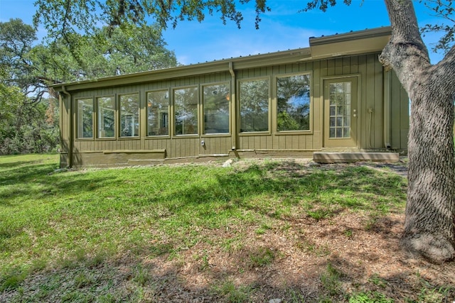 rear view of property with a lawn