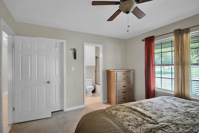 carpeted bedroom featuring ceiling fan and ensuite bath