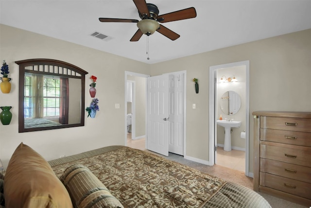 bedroom with ensuite bath, ceiling fan, and sink