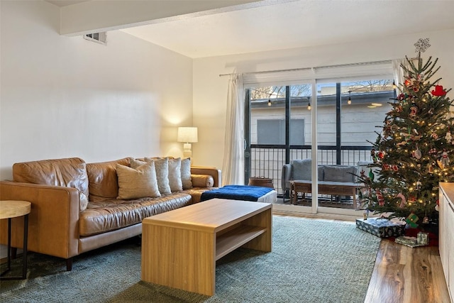 living area featuring visible vents, wood finished floors, and beamed ceiling