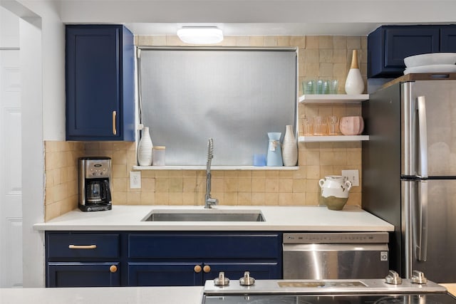 kitchen featuring blue cabinetry, a sink, appliances with stainless steel finishes, and decorative backsplash