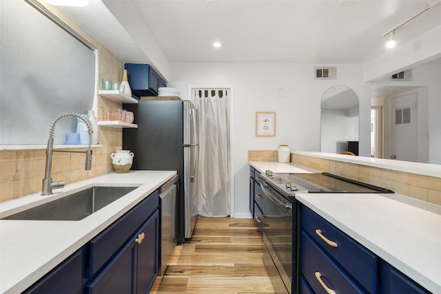 kitchen with stainless steel appliances, visible vents, a sink, and blue cabinetry