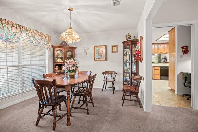 carpeted dining space with a notable chandelier