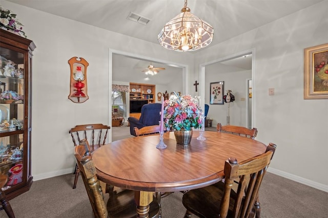 dining space with ceiling fan with notable chandelier, built in features, and carpet floors