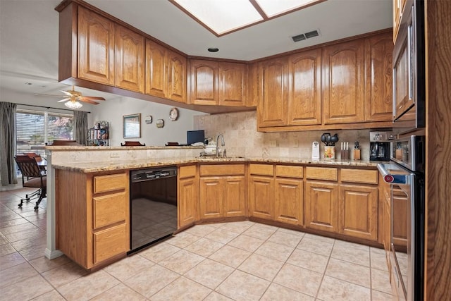 kitchen with kitchen peninsula, light stone counters, sink, black dishwasher, and light tile patterned flooring