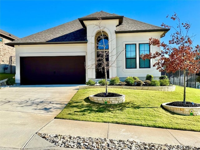 view of front of property featuring a garage and a front lawn