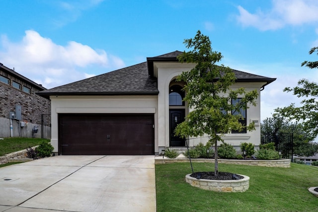 view of front of property with a shingled roof, a front yard, stucco siding, a garage, and driveway