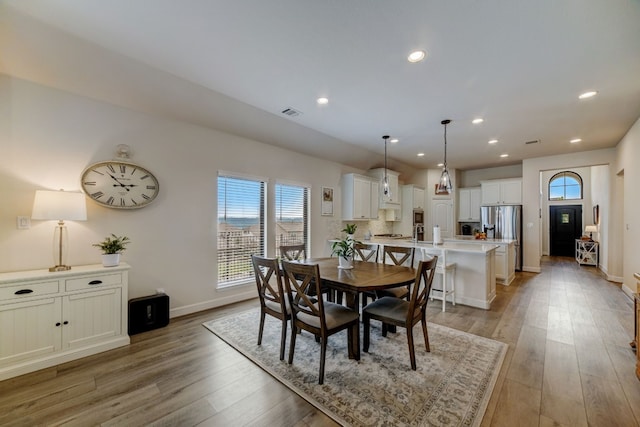 dining room with a wealth of natural light, light wood-type flooring, and baseboards