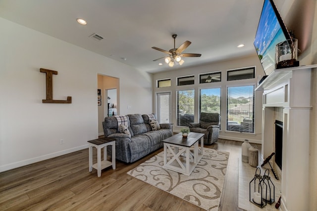 living area featuring recessed lighting, visible vents, and wood finished floors