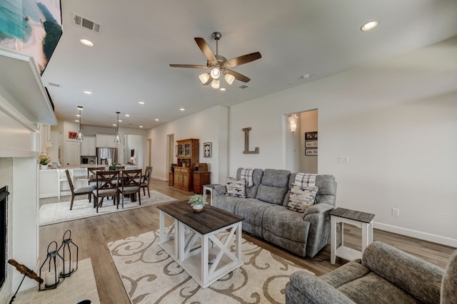 living room with recessed lighting, visible vents, and light wood-style flooring