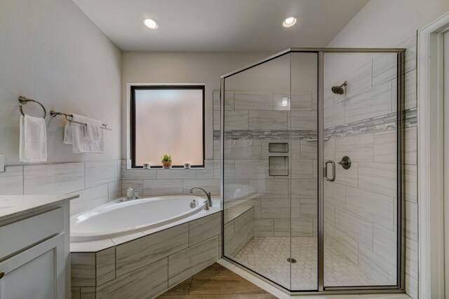 full bath with recessed lighting, vanity, a bath, and a shower stall