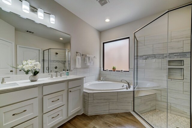 full bathroom featuring a sink, visible vents, a garden tub, and a shower stall