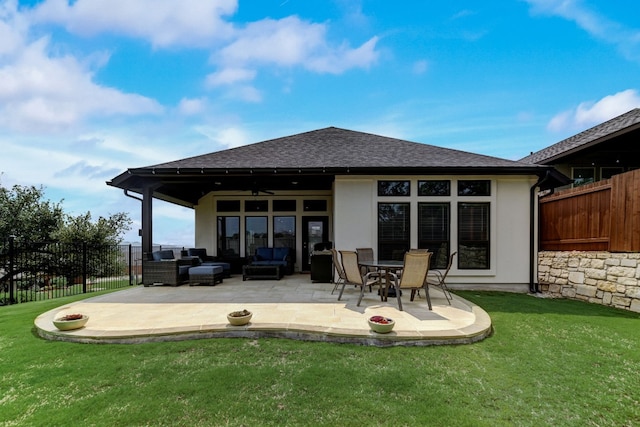 rear view of house featuring outdoor lounge area, a ceiling fan, a lawn, and a fenced backyard