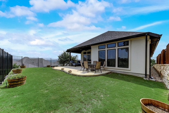 rear view of property featuring a fenced backyard, a yard, a patio, and roof with shingles