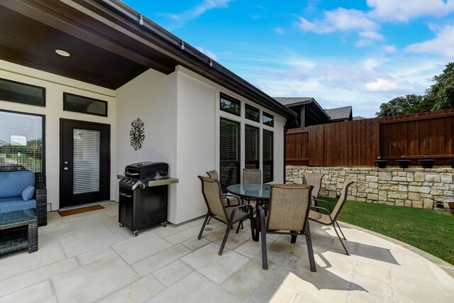 view of patio featuring outdoor dining area, area for grilling, and fence