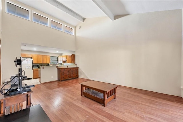 living room with vaulted ceiling with beams and light wood-type flooring