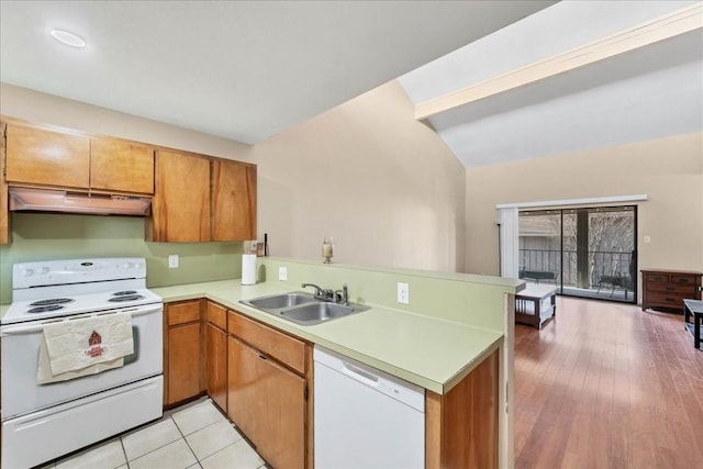 kitchen with lofted ceiling, white appliances, sink, light hardwood / wood-style flooring, and kitchen peninsula