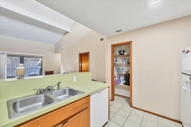 kitchen featuring dishwasher, light tile patterned floors, sink, and vaulted ceiling