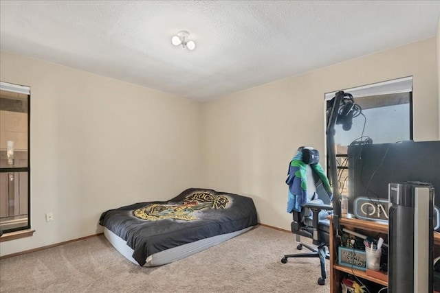 bedroom with a textured ceiling and light colored carpet